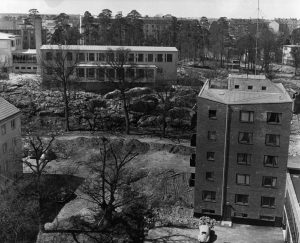 Vy av Spetsberget där Ekensbergsskolan ligger på kullen. Till vänster Vårvägen med ännu ofullbordad parkeringsplats. Ca 1959.